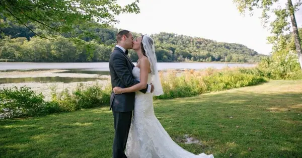 Newlyweds sharing a kiss by the lake